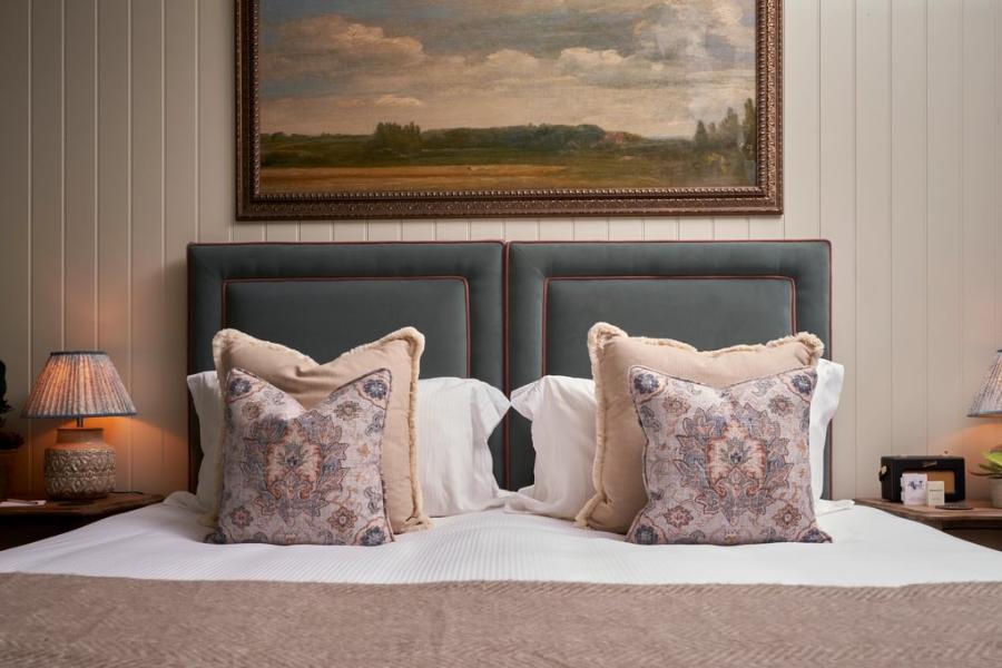 Book the Cotswolds - Wonderful Winchcombe A painting of English countryside hangs above a large bed with decorative cushions